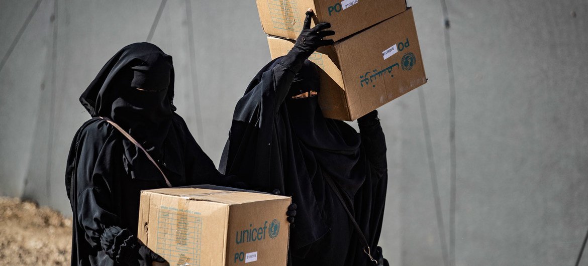 Displaced people living in Al-Hol camp in northeastern Syria carry newly received winter clothing kits, distributed by UNICEF. Displaced people living in Al-Hol camp in northeastern Syria carry newly received winter clothing kits, distributed by UNICEF.