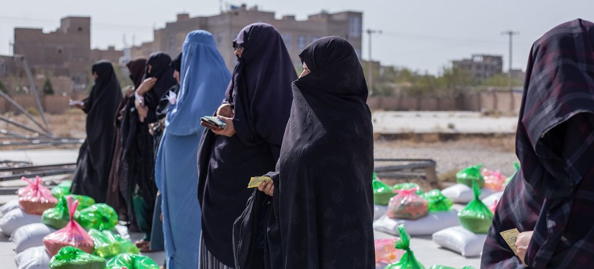 Des femmes reçoivent des rations alimentaires sur un site de distribution alimentaire à Herat, en Afghanistan.