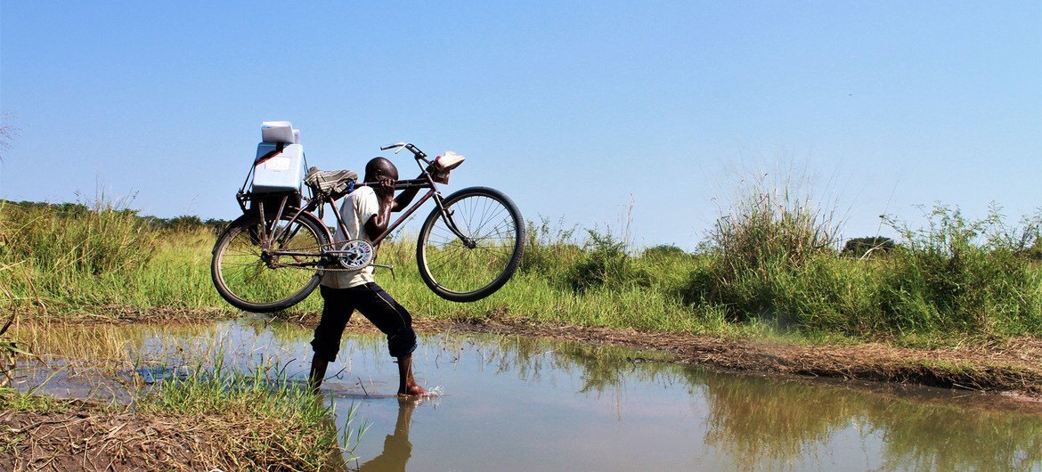 A health worker crosses a stream with his bike on his way to vaccinate children in Tanganyika Province in the Democratic Republic of the Congo. A health worker crosses a stream with his bike on his way to vaccinate children in Tanganyika Province in the Democratic Republic of the Congo.