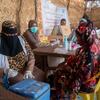 A woman holds a child while receiving medical care at a UNICEF-supported health center in Sudan's Kordofan region, where families have fled violence.