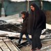 A Palestinian woman and child walk through the rubble of a destroyed tent in Mawasi, Khan Younis, Gaza Strip.