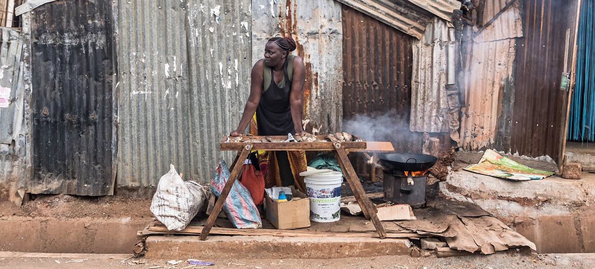 A female street vendor sells food in Africa. A female street vendor sells food in Africa.