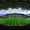 A panoramic view of the empty Melbourne Rectangular Stadium (AAMI Park), showing the green pitch and stadium seating under a modern roof structure.