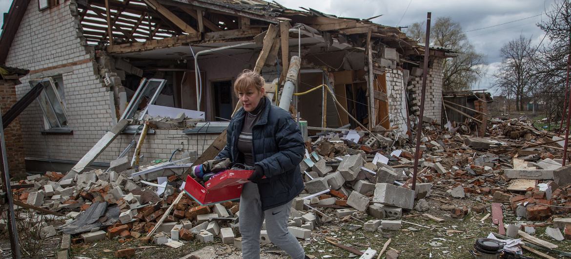 Bir kadın, Ukrayna'nın Chernihiv yakınlarındaki Novoselivka köyünde bombalanan evinden eşyalarını geri alıyor.