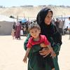 A Palestinian mother holds a young child at a refugee camp in Gaza.