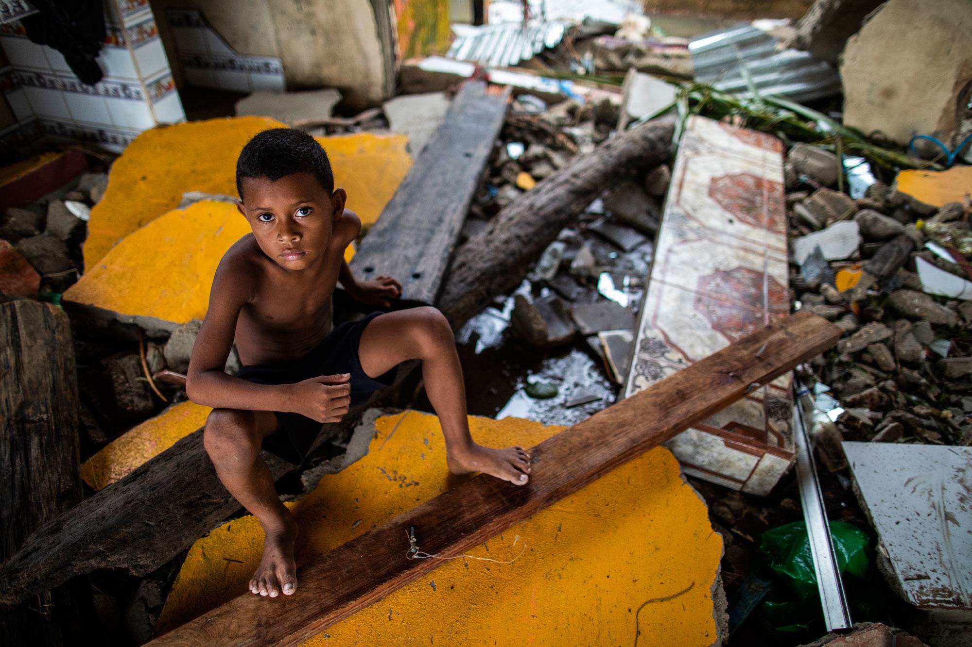 A boy sits on the debris of his house which was destroyed in Hurricane Iota in Bilwi, Nicaragua.