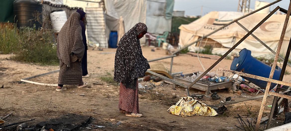 Two women in a damaged displacement camp in Gaza after bombardment.