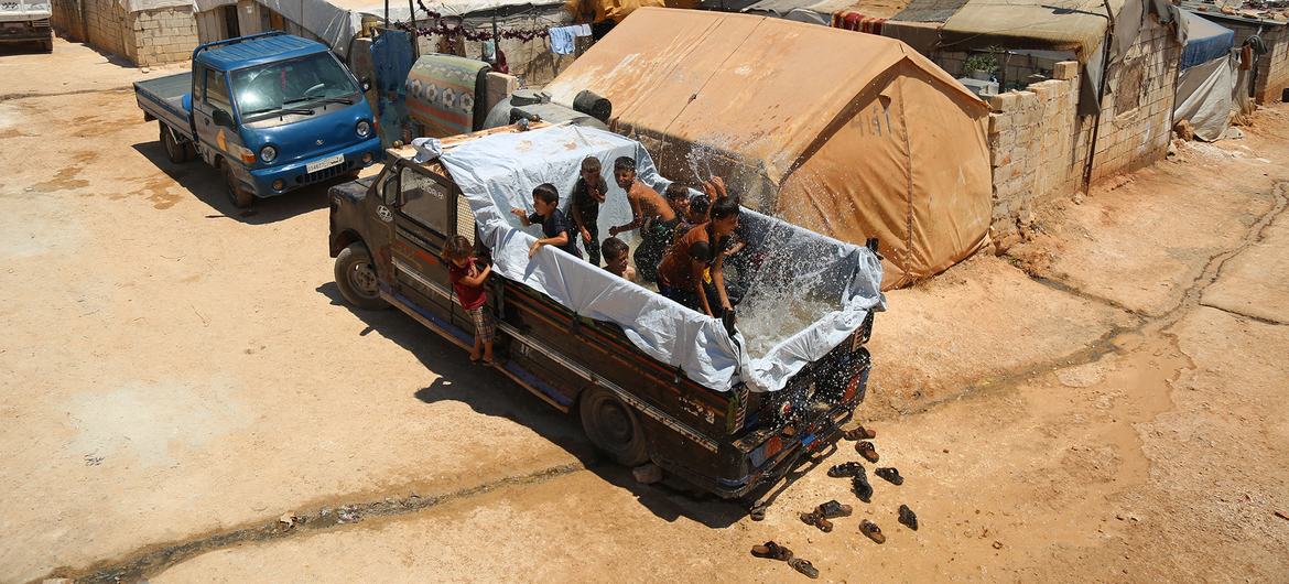 In a camp for people displaced by conflict in the north-west of Syria, children cool down from soaring summer temperatures in the back of a truck made into a temporary pool. 
