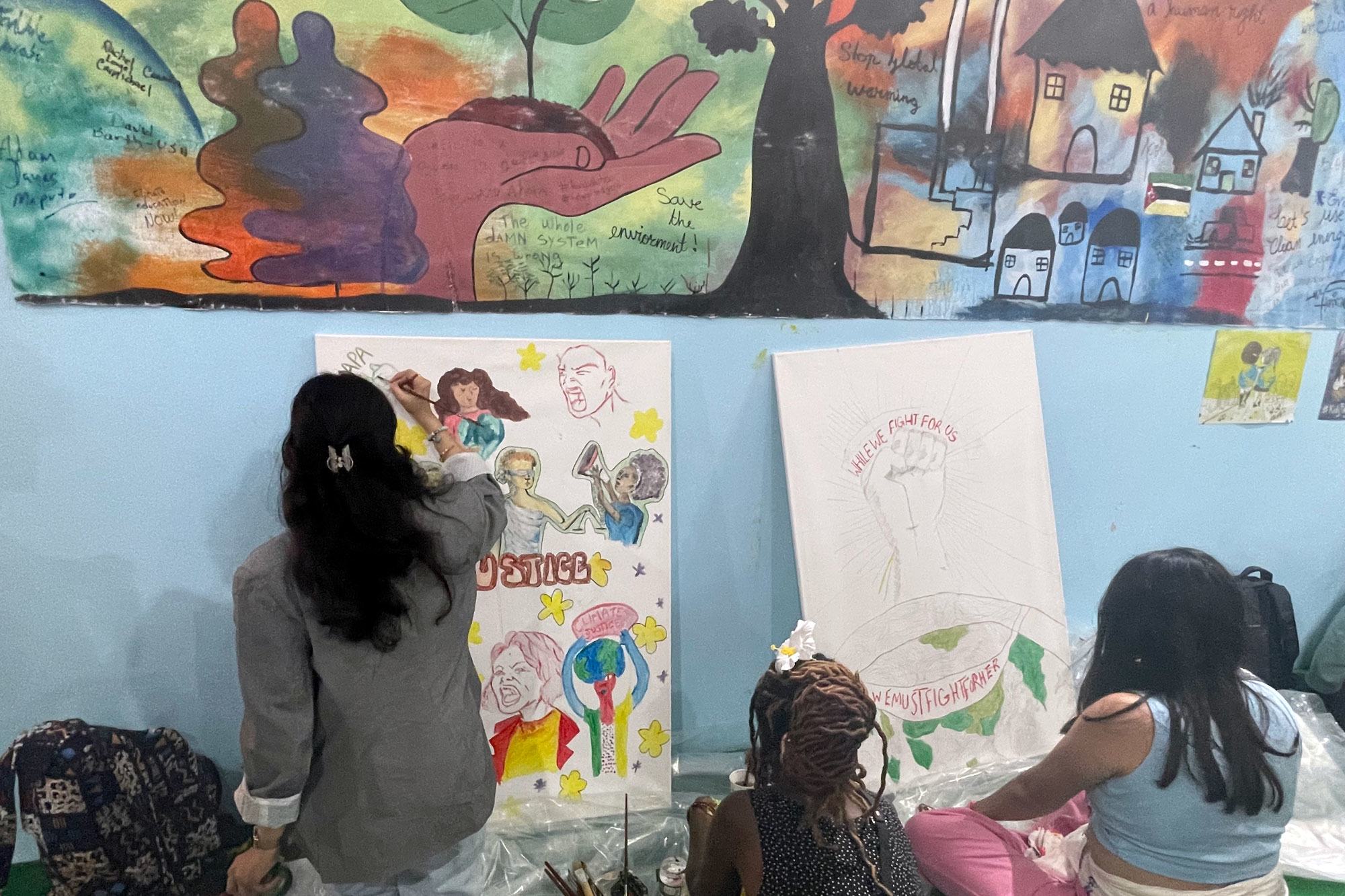 UNICEF youth advocate Ayshka Najib paints a collaborative artwork at the youth pavilion.