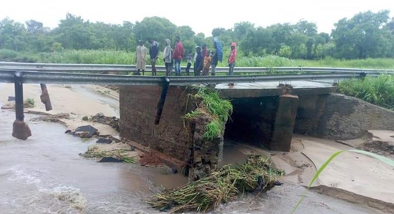 Ana Tropik Fırtına'nın ardından Mozambik'te karaya inen insanlar hasarlı bir köprüde duruyor.