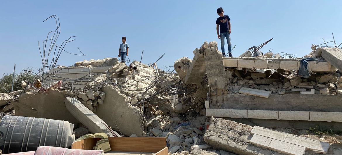 Children stand in front of a demolished house in Beit Sira, a Palestinian village in the central West Bank.