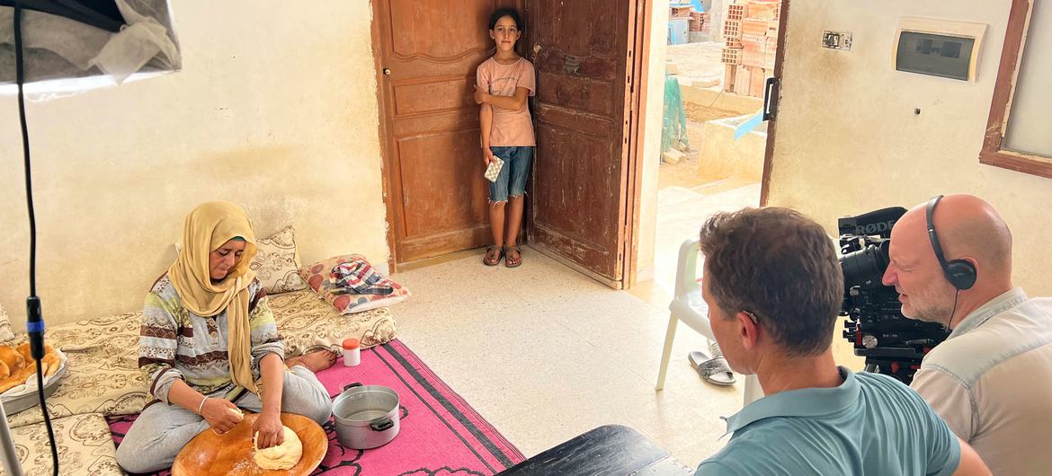 Najwa Selmi, at home with her daughter, demonstrates to a UNTV film crew how to make traditional ‘tabouna’ bread.