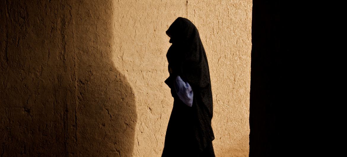 A woman walks through a corridor in a village in Zindajan district, Afghanistan. A woman walks through a corridor in a village in Zindajan district, Afghanistan.