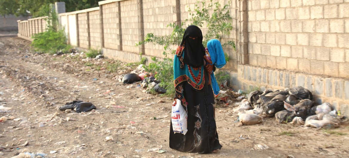 A woman, carrying her child who suffers from severe malnutrition and health complications, walks to a health centre in Hudaydah governorate, Yemen. A woman, carrying her child who suffers from severe malnutrition and health complications, walks to a health centre in Hudaydah governorate, Yemen.