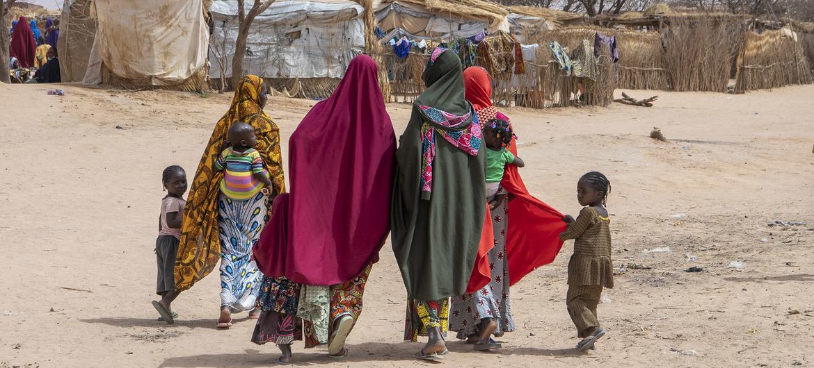 A displaced family walks through Ouallam camp in Niger. A displaced family walks through Ouallam camp in Niger.