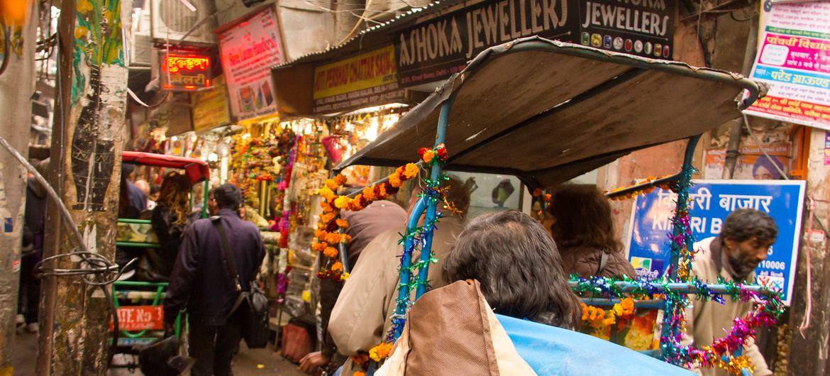 Turistler çekçek aracılığıyla Hindistan'ın Delhi kentindeki tarihi Chandni Chowk pazarını keşfederler.
