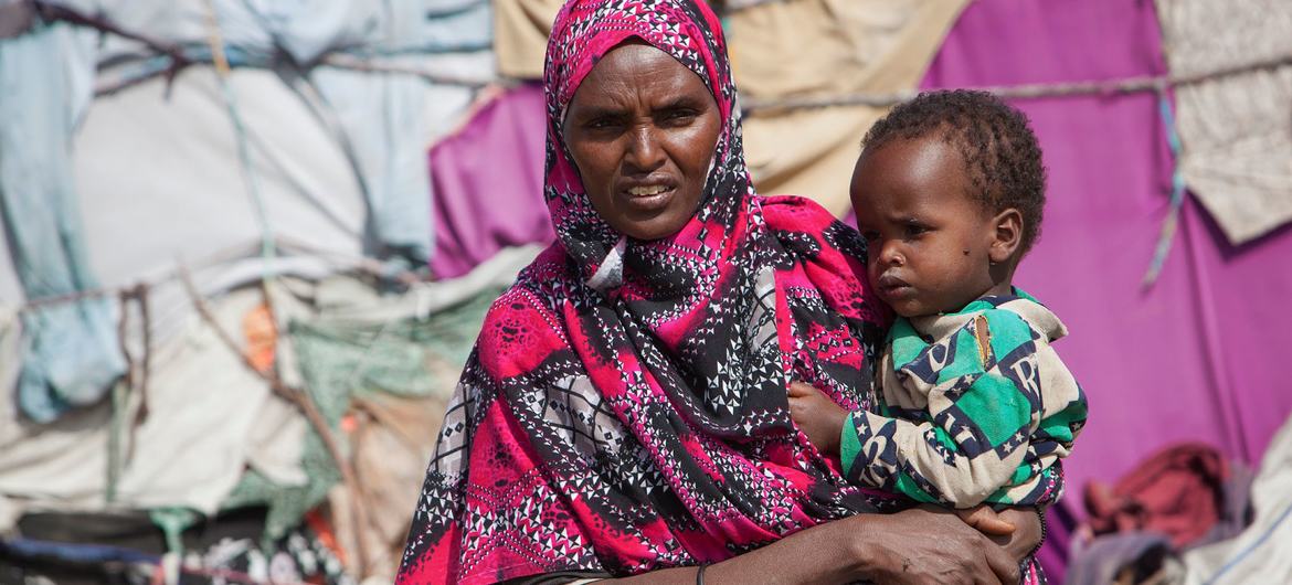 A mother holds her child in a displaced persons camp in Somalia after being forced to leave her home due to drought. A mother holds her child in a displaced persons camp in Somalia after being forced to leave her home due to drought.