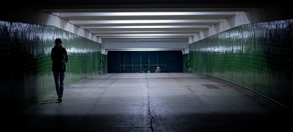 A woman walks through a tunnel in a metro station in Kharkiv, Ukraine, where people are taking shelter from the conflict.