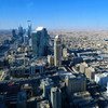 Aerial view of the Riyadh city skyline in Saudi Arabia, featuring modern skyscrapers and a dense urban landscape under a clear blue sky.