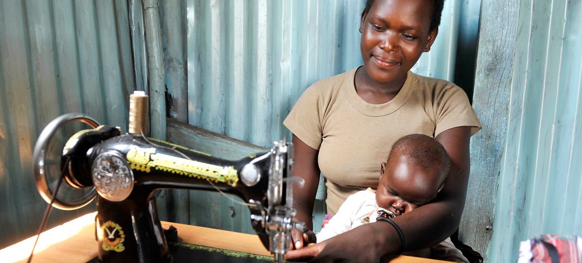 A mother works as a tailor while taking care of her baby in Suba, Kenya. A mother works as a tailor while taking care of her baby in Suba, Kenya.