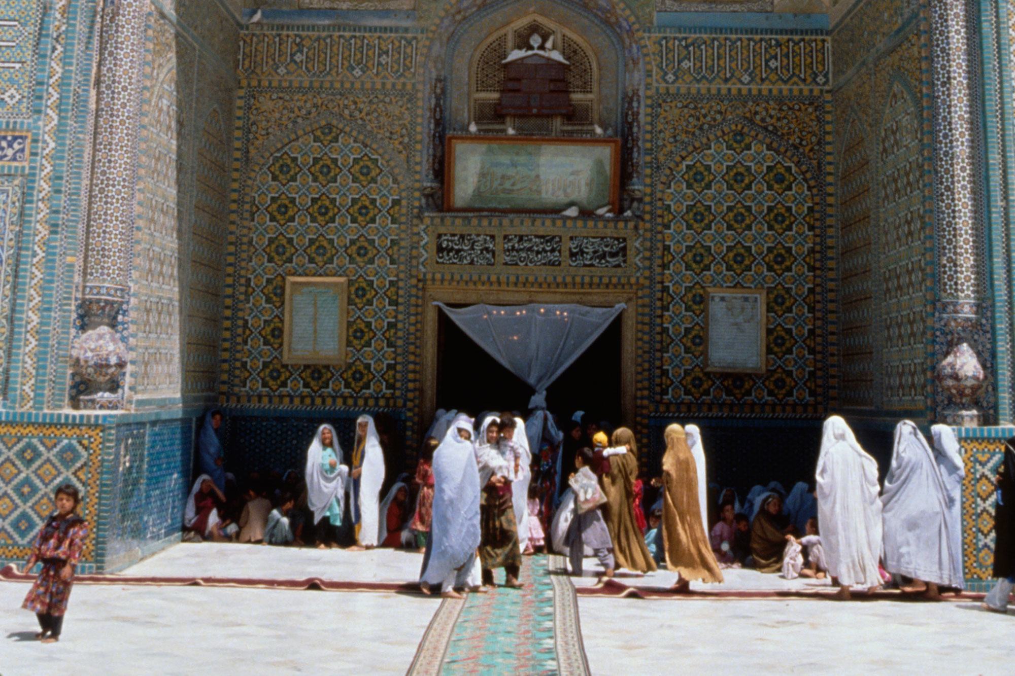 Women gather in the shade of the high archway entrance to a mosque in the northern city of Mazar-i-Sharif, Afghanistan. Women gather in the shade of the high archway entrance to a mosque in the northern city of Mazar-i-Sharif, Afghanistan.