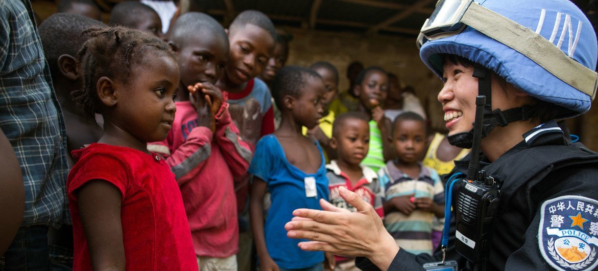 A Chinese police officer deployed to the UN Mission in Liberia (UNMIL), talks to a young girl whilst on patrol (file photo). A Chinese police officer deployed to the UN Mission in Liberia (UNMIL), talks to a young girl whilst on patrol (file photo).