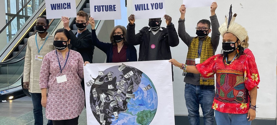 A group armed with signs pose for photographers at the main corridor of the Blue Zone at the COP26 Climate Conference in Glasgow, Scotland. A group armed with signs pose for photographers at the main corridor of the Blue Zone at the COP26 Climate Conference in Glasgow, Scotland.