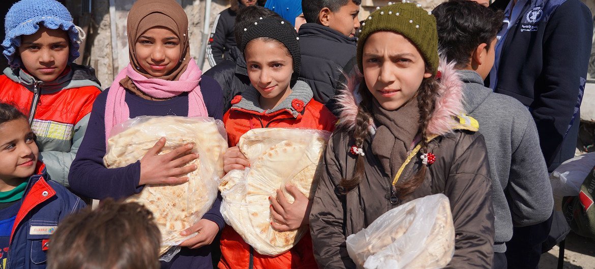 Çocuklar, WFP'nin gıda dağıtımına yardım ettiği Suriye'nin Halep kentindeki bir fırından ekmek alıyor.
