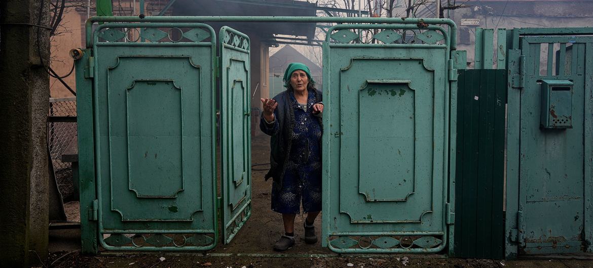 A woman looks at her damaged house after shelling in Mariupol, southeastern Ukraine.