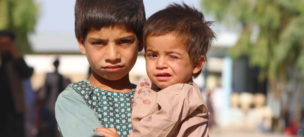 A five-year-old boy holds his younger brother in a displaced persons camp in Kandahar, southern Afghanistan. A five-year-old boy holds his younger brother in a displaced persons camp in Kandahar, southern Afghanistan.