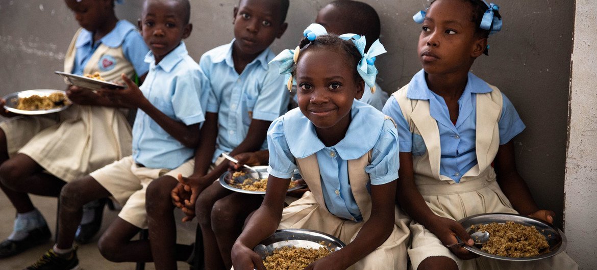 Children at a school in Haiti enjoy food provided as part of WFP's school canteen programme.