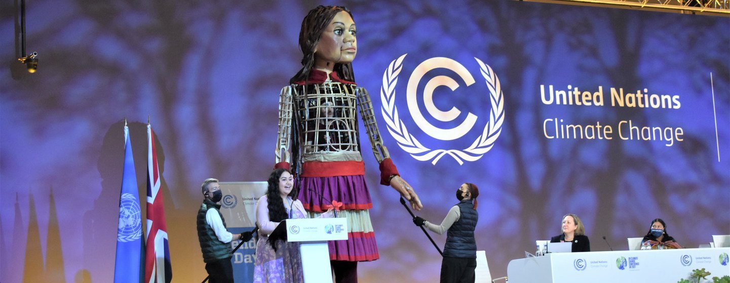 Samoan Activist Brianna Fruean shares the podium of the COP26 plenary with Little Amal, a giant puppet representing a Syrian refugee girl. Samoan Activist Brianna Fruean shares the podium of the COP26 plenary with Little Amal, a giant puppet representing a Syrian refugee girl.