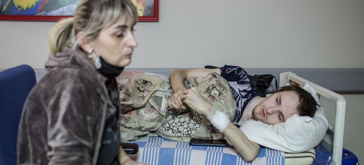 On 3 March 2022, a woman sits beside the stretcher of her son, who has been receiving treatment for three weeks at a hospital in Kyiv, Ukraine. On 3 March 2022, a woman sits beside the stretcher of her son, who has been receiving treatment for three weeks at a hospital in Kyiv, Ukraine.