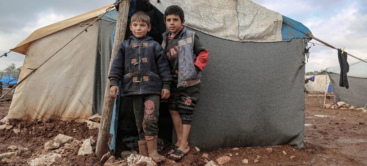 Children, whose families were displaced due to the war in Syria, stand outside their shelter, in the north of the country. Children, whose families were displaced due to the war in Syria, stand outside their shelter, in the north of the country.