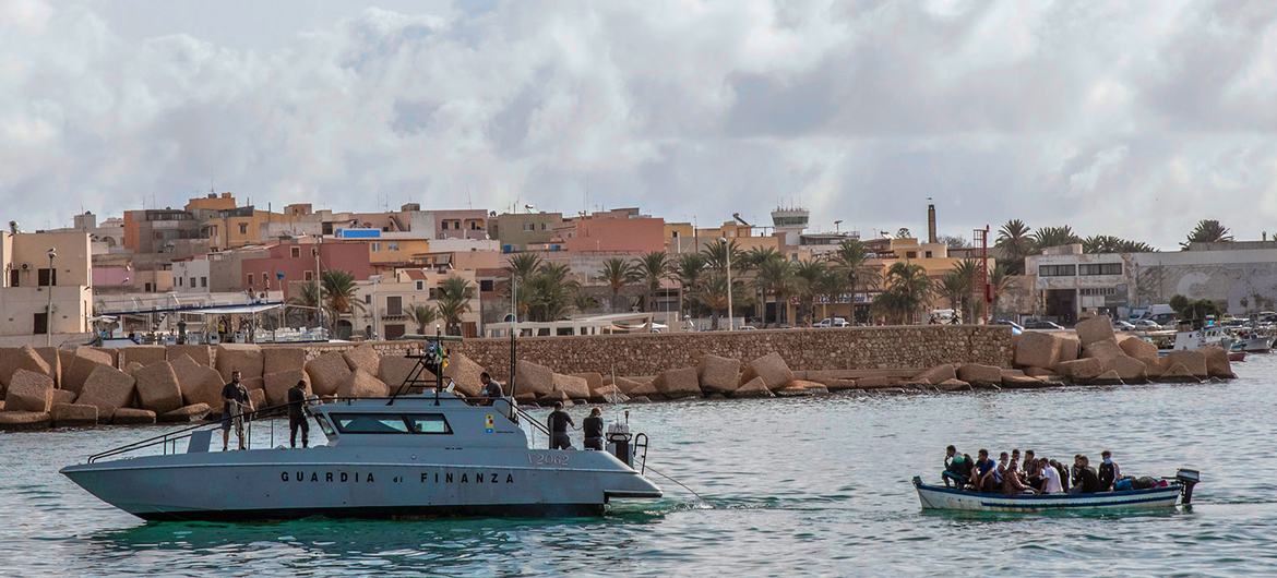 Refugees and migrants in a wooden boat are rescued near the Italian island of Lampedusa in the Mediterranean Sea. Refugees and migrants in a wooden boat are rescued near the Italian island of Lampedusa in the Mediterranean Sea.