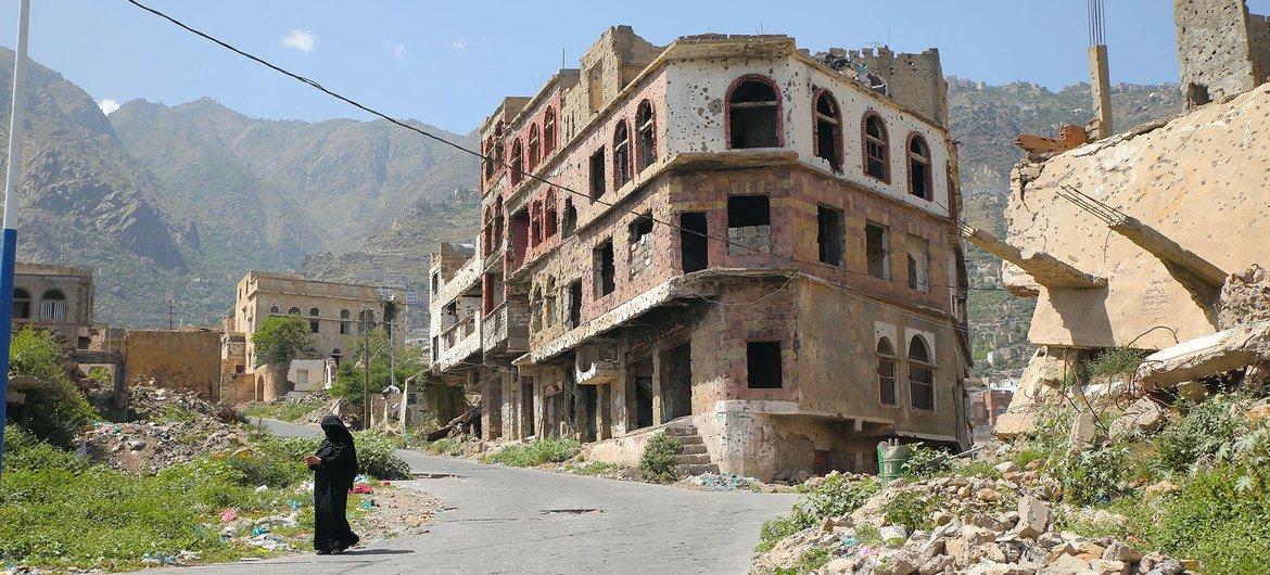 A woman walks in Taiz, a war-ravaged city in Yemen, split by a frontline. A woman walks in Taiz, a war-ravaged city in Yemen, split by a frontline.