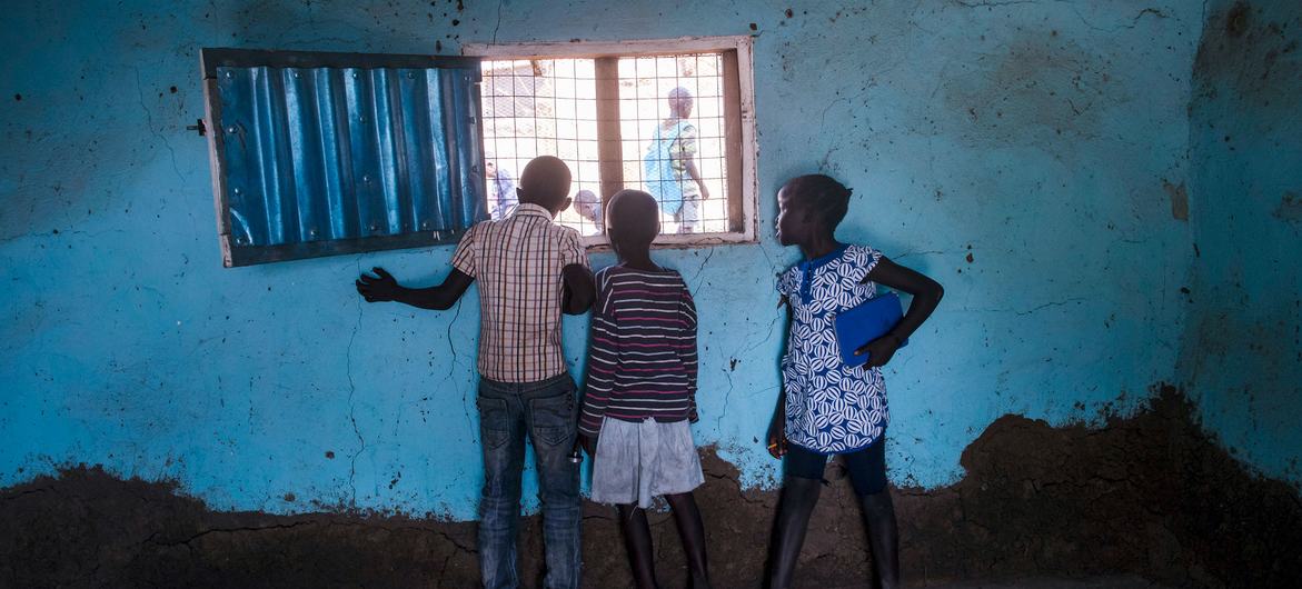 Children look out of a window in South Sudan. Children look out of a window in South Sudan.