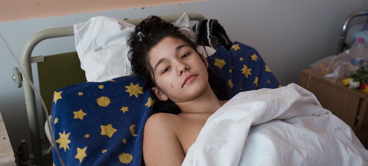 Yaralı bir kız, arabasının bombalanmasının ardından Ukrayna'nın Kiev kentinde bir sağlık koğuşunda dinleniyor.