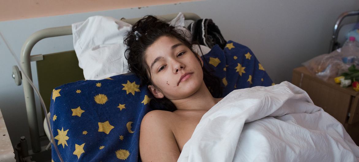 An injured girl rests in a medical ward in Kyiv, Ukraine, after her car exploded.