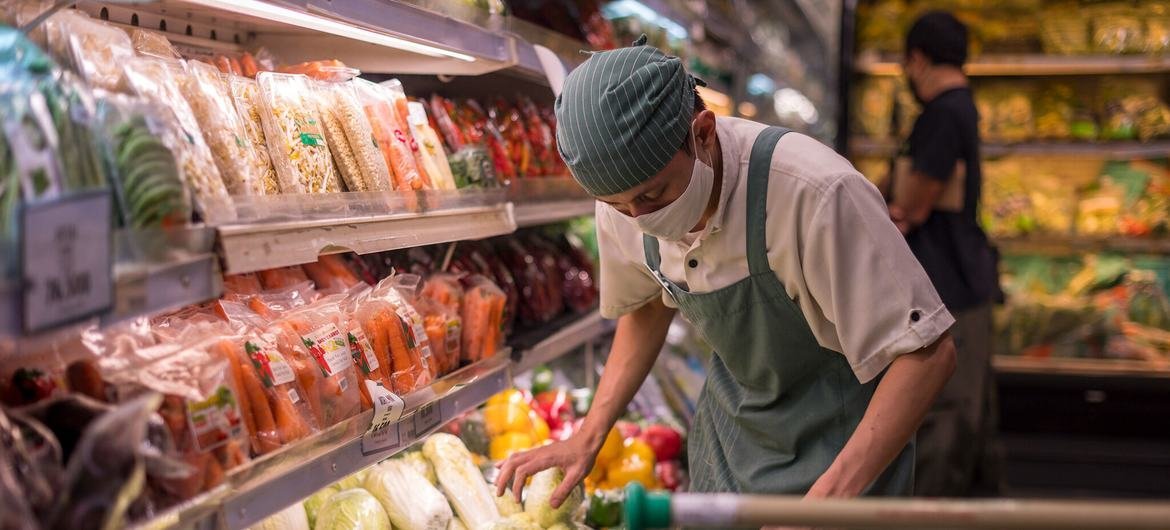 An employee arranges vegetables in a supermarket in Indonesia. An employee arranges vegetables in a supermarket in Indonesia.