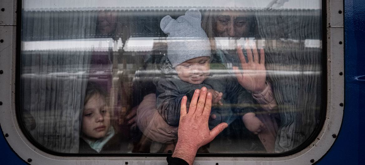 In Kharkiv, Ukraine, a man put his hand on the window of a train as he said goodbye to his wife and children before they departed on a special evacuation train.