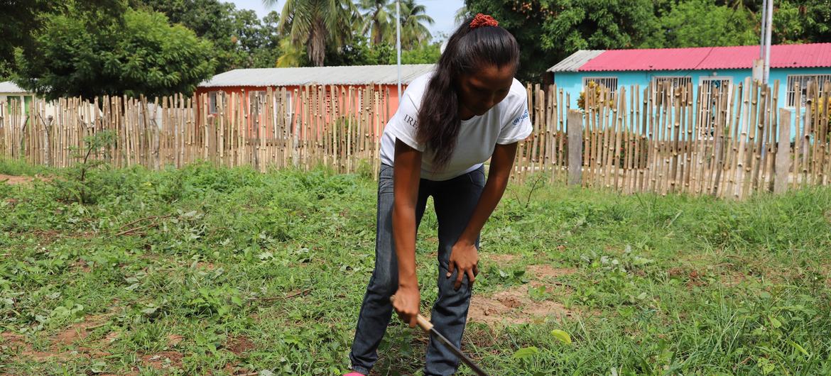 Kadın ağının üyesi ve bahçede toprağı dikim için hazırlayan katılımcı.