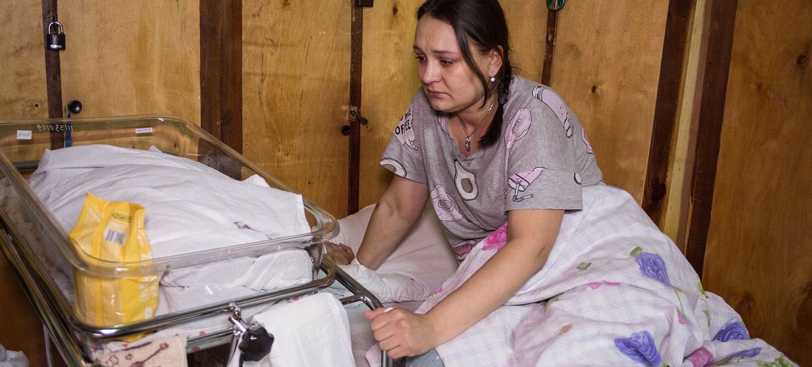 A new mother sits in a bed next to her baby in a makeshift maternity ward in a hospital in Kyiv, Ukraine. A new mother sits in a bed next to her baby in a makeshift maternity ward in a hospital in Kyiv, Ukraine.