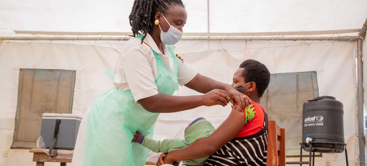 A nurse administers the COVID vaccine to a woman in a health centre in Uganda. A nurse administers the COVID vaccine to a woman in a health centre in Uganda.