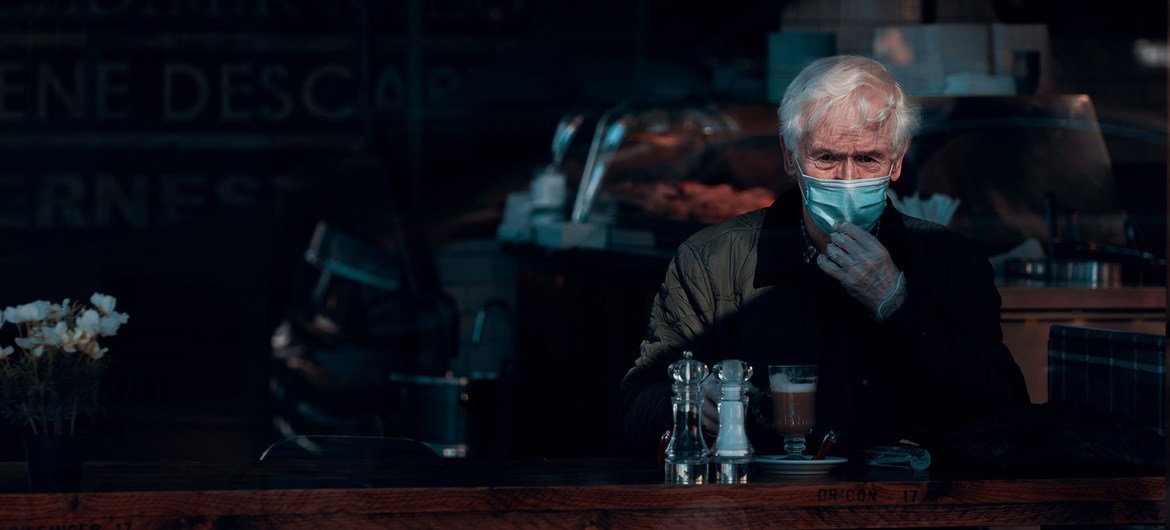 A man wears a face mask and gloves while sitting in a cafe in Glasgow, Scotland. A man wears a face mask and gloves while sitting in a cafe in Glasgow, Scotland.