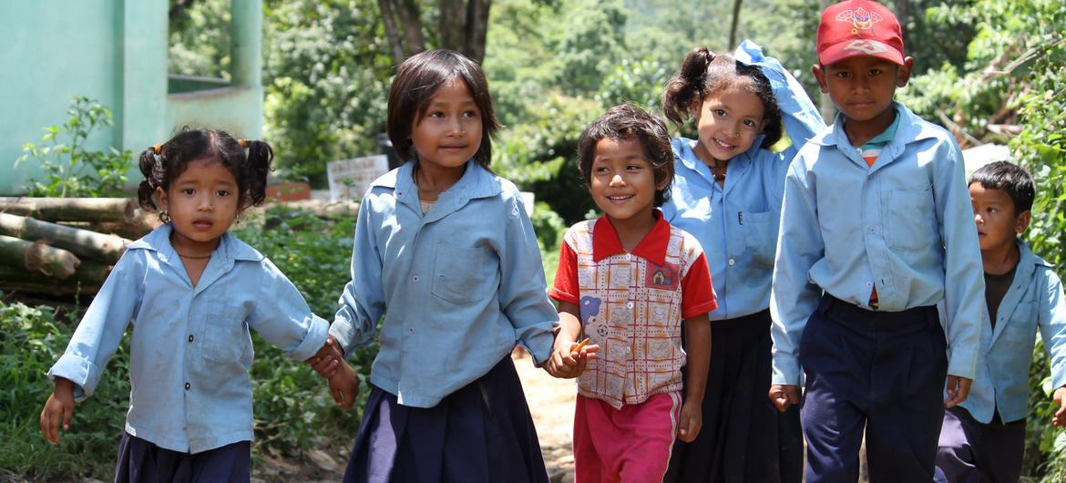 A group of school children walk hand in hand after school in rural Nepal. A group of school children walk hand in hand after school in rural Nepal.