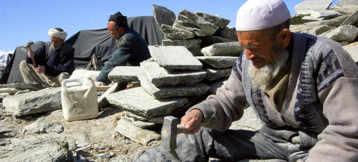 A group of Afghan men use hand tools to process rocks at a site in Kabul. A group of Afghan men use hand tools to process rocks at a site in Kabul.
