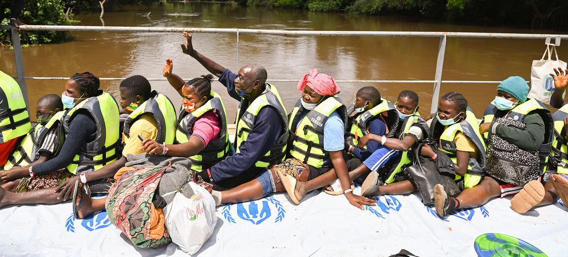 Ivorian refugees wave to waiting friends and family from a barge carrying them from Liberia back to Côte d’Ivoire. Ivorian refugees wave to waiting friends and family from a barge carrying them from Liberia back to Côte d’Ivoire.