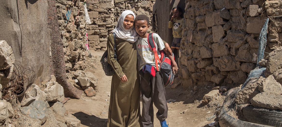 A twelve-year-old Yemeni girl and her brother tutor math.