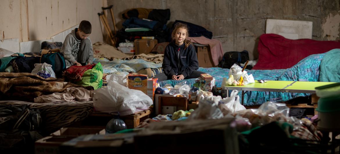 Alina and Artem, who are both aged nine and from the northeastern city of Kharkiv in Ukraine, sit on a makeshift sofa in the underground car park which serves as a bomb shelter. Alina and Artem, who are both aged nine and from the northeastern city of Kharkiv in Ukraine, sit on a makeshift sofa in the underground car park which serves as a bomb shelter.